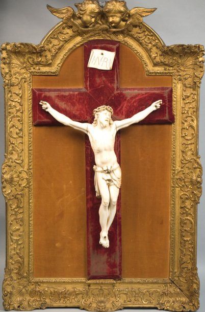 null Important crucifix, le cadre en bois doré, le haut cintré sculpté de deux têtes...