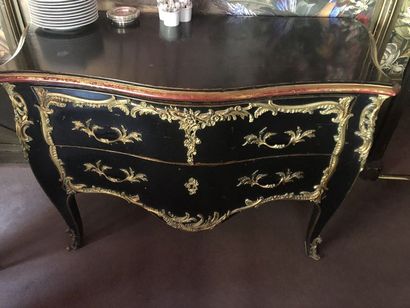 null Commode galbée ouvrant par deux tiroirs, bois laqué noir. Ornementation bronze...