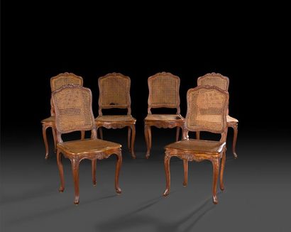 null Six chaises cannées en hêtre teinté, mouluré et sculpté à décor de feuillages,...