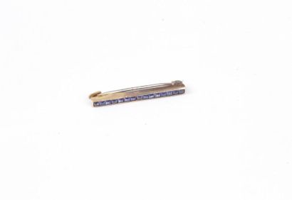 null 18K (750) gold bar brooch set with synthetic sapphires. Length: about 2.5 cm....