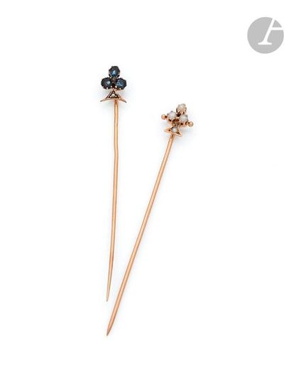 null A set of two 18K (750) gold pins each with a clover, one set with round sapphires...