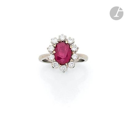 null 18K (750) white gold ring set with an oval-shaped ruby weighing 1.91 ct surrounded...