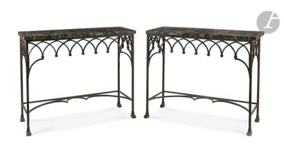 null A pair of wrought iron console tables decorated with arcatures, the legs ending...