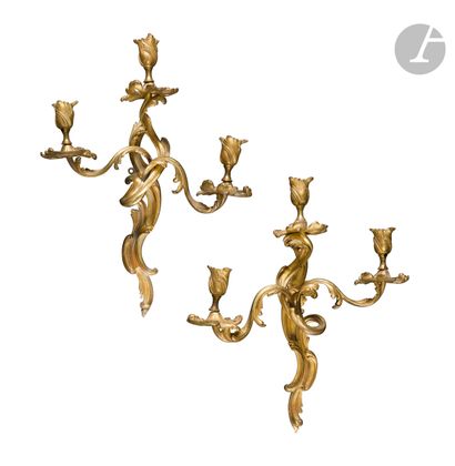 null A pair of three-branch varnished bronze sconces with openwork foliage.
Louis...