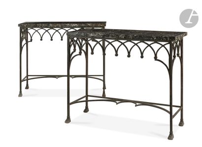 null A pair of wrought iron console tables decorated with arcatures, the legs ending...