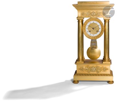 null A gilt bronze clock of portico form, with four columns framing a dial with Roman...