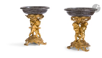 null A pair of grey granite bowls, the gilt bronze base decorated with children holding...