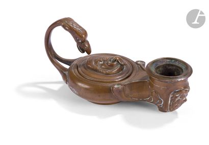 null A small antique oil lamp with an eagle head and a mask of the Comédie; inscribed...