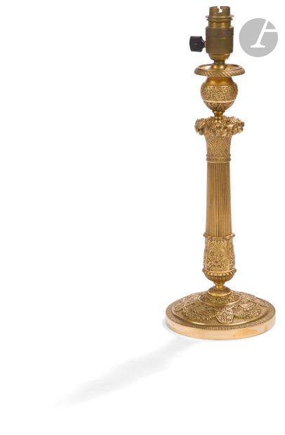 null A gilt bronze lamp stand decorated with cornucopia and foliage, the fluted shaft...