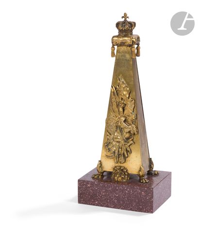 null Gilt bronze obelisk decorated with a military trophy and a lion's head, surmounted...