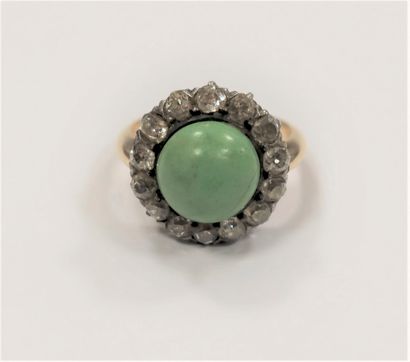 null Bague en or 18K (750), ornée d’une turquoise cabochon entourée de 14 diamants...