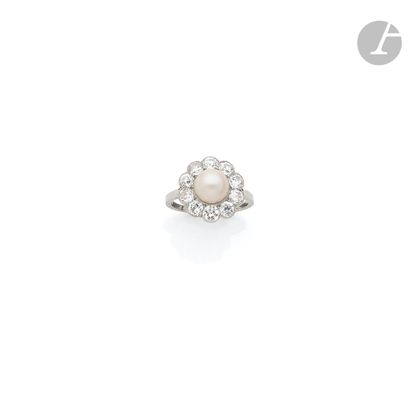 null A platinum ring, set with a button pearl surrounded by 10 round old cut diamonds....