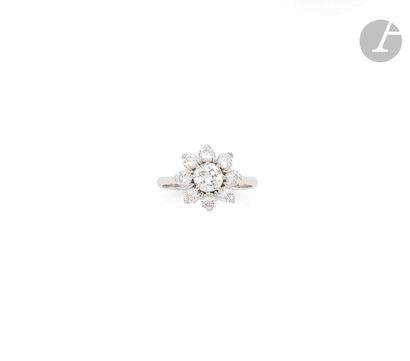 null An 18K (750 ‰) white gold ring, adorned with a round half-cut diamond surrounded...