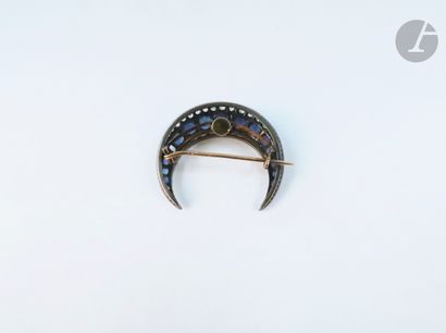 null Silver and 18K (750 ‰) gold brooch drawing a crescent moon, set with a line...