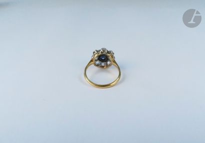 null An 18K (750 ‰) gold daisy ring, set with a round sapphire surrounded by 8 round...