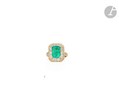 null An 18K (750 ‰) gold ring, set with a rectangular cut emerald surrounded by round...