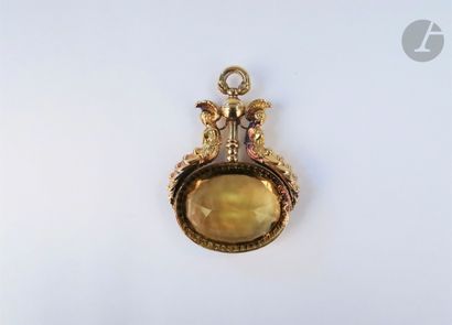null 18K (750 ‰) gold pendant adorned with leaning terms framing an oval-shaped citrine....