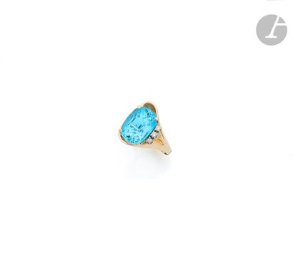 null 14K gold (585 ‰) asymmetrical ring, adorned with a cushion-shaped blue topaz,...