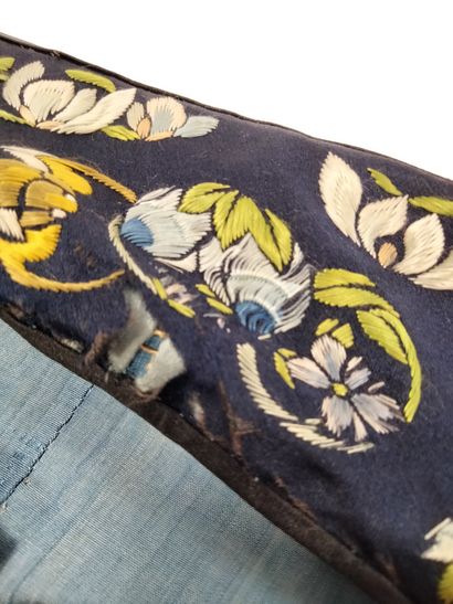 null CHINE, vers 1900
Robe en soie brodée de fleurs et de papillons sur fond bleu...