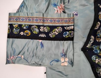 null CHINE, vers 1900
Robe en soie brodée de fleurs et de papillons sur fond bleu...
