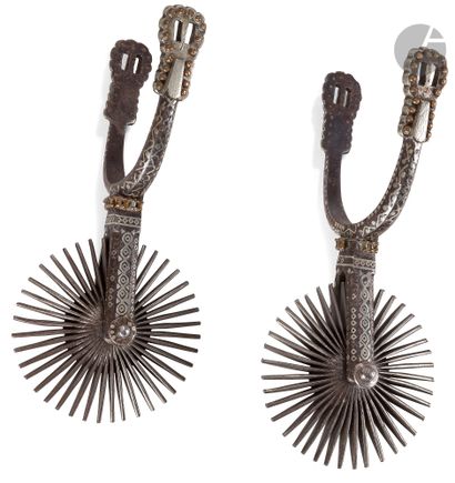 null Pair of Mexican spurs.

Wrought iron arms fully inlaid with silver designs and...