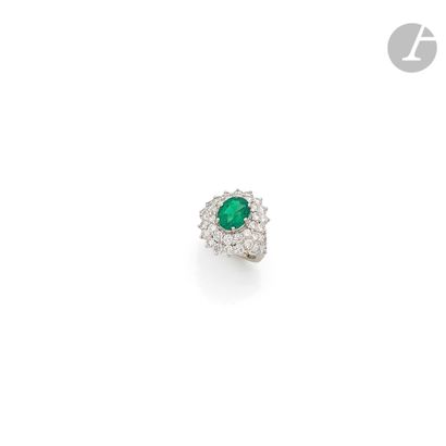 null Platinum ring set with an oval emerald surrounded by round brilliant-cut diamonds....