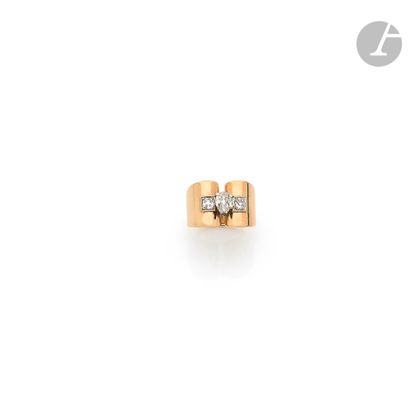 null An 18K (750) gold pinky ring, set with a pear-shaped diamond between two round...