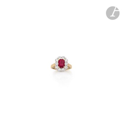 null 18K (750) gold ring, set with a ruby surrounded by 10 round brilliant-cut diamonds....