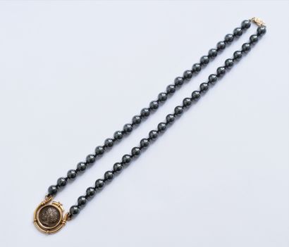  Necklace of hematite beads set with a silver coin mounted in 14K gold (585). Gross...