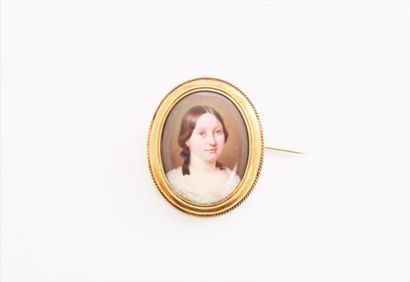  An 18K (750) gold brooch with a polychrome enamelled miniature of a young girl....
