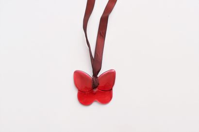 null BACCARAT. Red crystal pendant representing a butterfly, mounted on a silk ribbon....