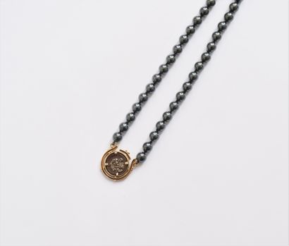 null Necklace of hematite beads set with a silver coin mounted in 14K gold (585)....
