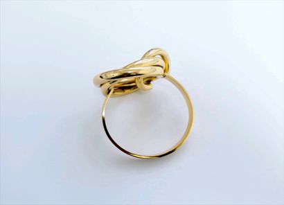 null Christian DIOR. Bracelet ouvrant en métal doré centré d'un motif nœud.