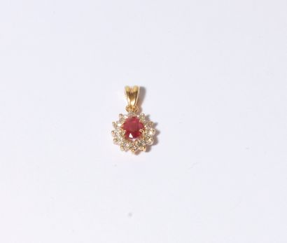 null Pendant in 18K (750) gold, set with an oval ruby surrounded by 12 round diamonds....