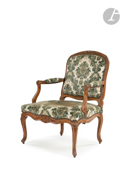 null A moulded, carved and stained wooden armchair with a flat rounded back, decorated...