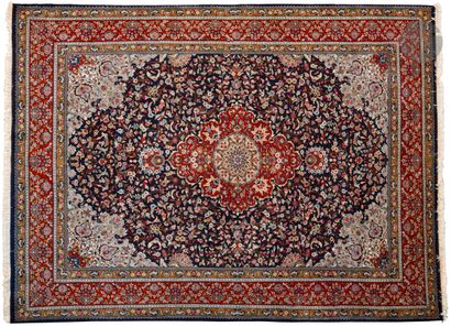 null Carpet decorated with a large red medallion on a navy blue background with garlands...