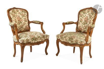 null A pair of moulded and carved beechwood armchairs, with foliage and flowers decoration,...