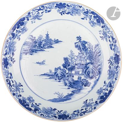  Grand plat rond en porcelaine blanche émaillée en bleu sous couverte d’un décor...