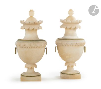 null A pair of large carved alabaster vases, decorated with foliage; (accidents and...