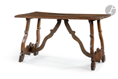 null A walnut skirted table with openwork base, the rectangular top; (accidents and...