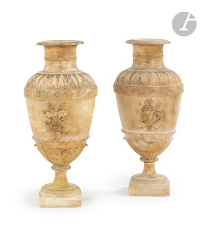 null A pair of sculpted alabaster vases of baluster form decorated with foliage,...