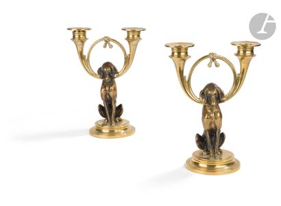 null Pair of bronze and brass candelabras representing a hunting dog holding hunting...
