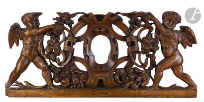 null Carved oak pediment with two cherubs supporting a leather shield frame with...
