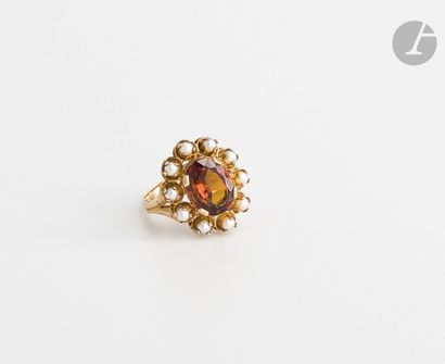 null Bague en or 18K (750), ornée d'une pierre orange entourée de perles de culture....