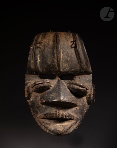 null A beautiful and very old mask with a double look, its mouth open, its slightly...