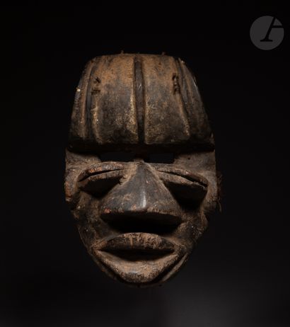 null A beautiful and very old mask with a double look, its mouth open, its slightly...