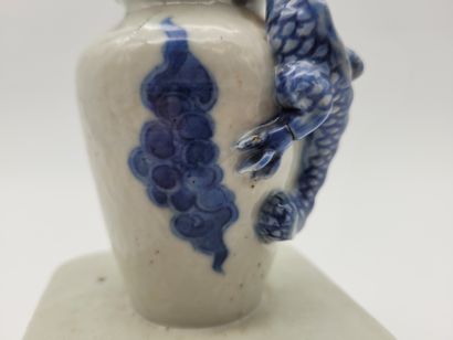 null Petit vase en porcelaine à décor bleu blanc sur un socle ajouré, surmonté par...