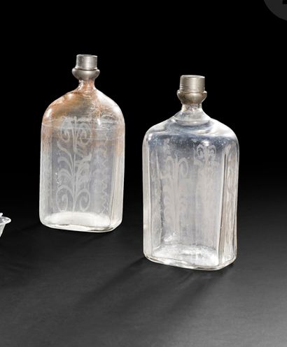 null Pair of blown glass spirit bottles, molded and engraved with a stylized floral...