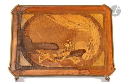 null Writing table in marquetry with musical instruments, the top resting on a belt...