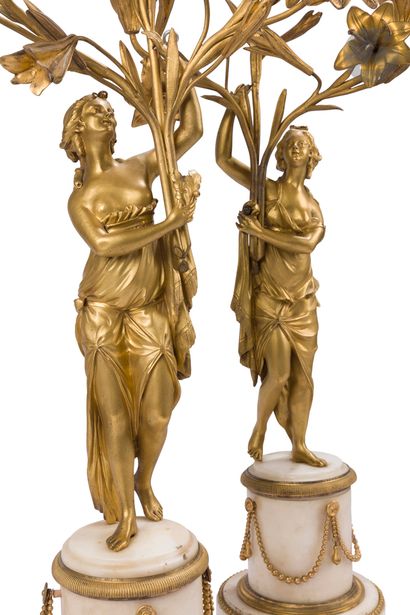 null Pair of candelabras with draped women in white marble and gilt bronze, with...